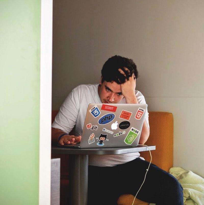 Male developer looking frustrated in front of a laptop